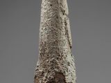 a close up of a stone object on a stand on a gray surface