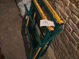 une photo d'un banc vert et jaune adossé à un mur de pierre