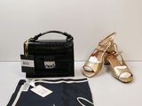 un sac à main noir et une paire de chaussures dorées à côté d'un sac à main noir