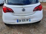 the back end of a white car parked in a parking lot