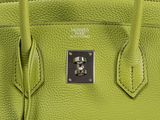 hermes ' s green leather handbag with a lock on the handle