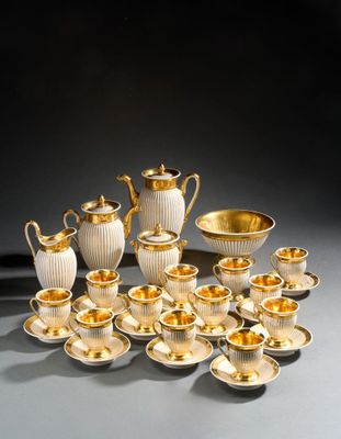 a group of silver and gold tea and coffee cups and saucers