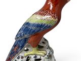 a figurine of a parrot sitting on a rock