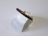 un gros plan d'une bague posée sur un support, sur fond blanc