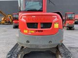 the back end of a red tractor parked in a parking lot
