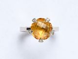 une bague sertie d'un saphir jaune et de diamants, sur fond blanc