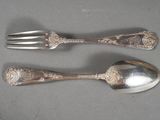 two silver spoons and a fork on a table