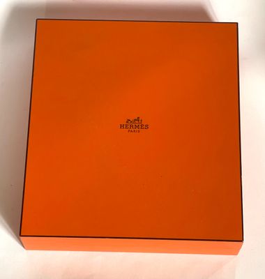 an orange box with a logo on it sitting on a white surface