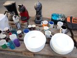 many plates and cups sitting on a pallet on the street