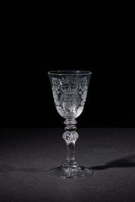 a wine glass sitting on a table with a black background
