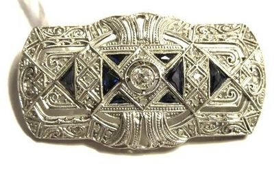 an antique silver belt buckle with a blue stone in the center