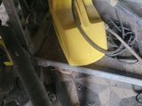 a yellow bucket sitting on the floor next to a yellow machine
