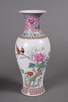un vase blanc orné d'un oiseau et de fleurs