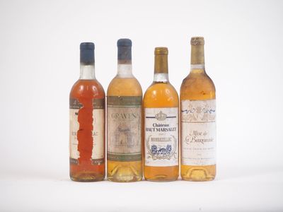 quatre bouteilles de vin sont alignées sur une surface blanche