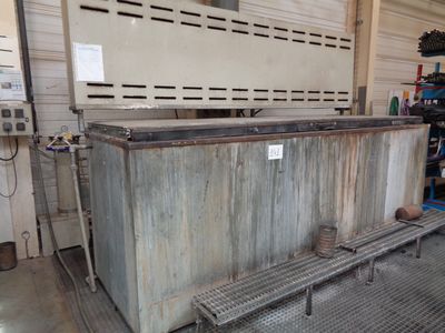 a large metal box sitting in a garage with a bench