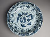 blue and white plate with flowers and vines on it