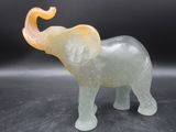 un éléphant en verre posé sur une surface noire