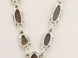 the necklace is made of silver and brown stones
