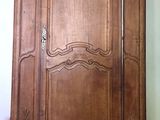 une grande armoire en bois dans le coin d'une pièce
