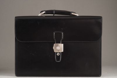 porte-documents en cuir noir avec fermoir argenté sur fond blanc