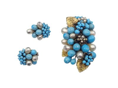 deux bijoux bleus et argentés posés sur une surface blanche