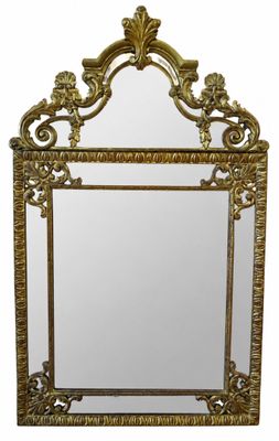 an ornate gold framed mirror with a bird and flower design