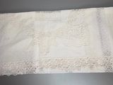 a white table cloth with lace on it on a table