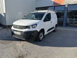 la camionnette blanche est garée devant un bâtiment dans un parking