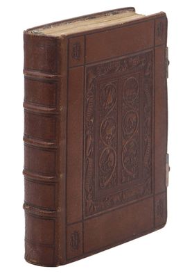 un vieux livre relié en cuir dont la couverture est ornée d'un motif décoratif