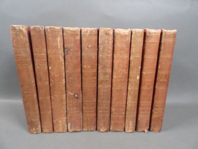 several old books stacked on top of each other on a gray surface