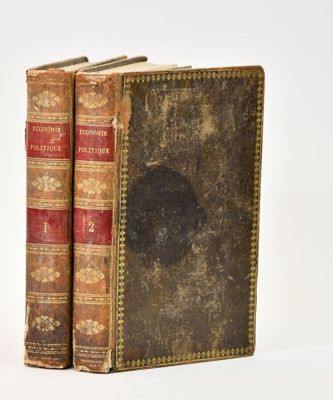 two old books sitting on top of each other on a white surface