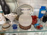 une étagère en verre sur laquelle sont disposés de nombreux vases en verre