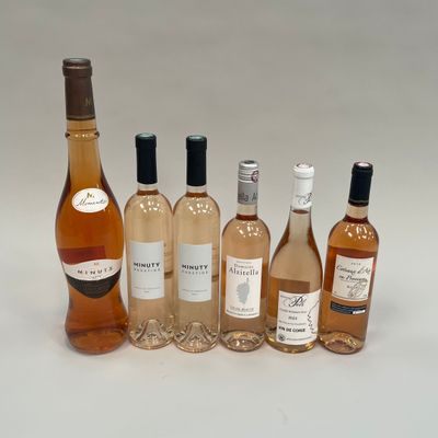 plusieurs bouteilles de vin posées les unes à côté des autres sur une surface blanche
