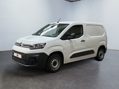 La camionnette blanche est garée dans une grande pièce blanche.