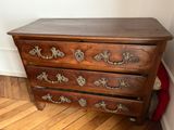 a wooden chest of drawers in a room with wood flooring