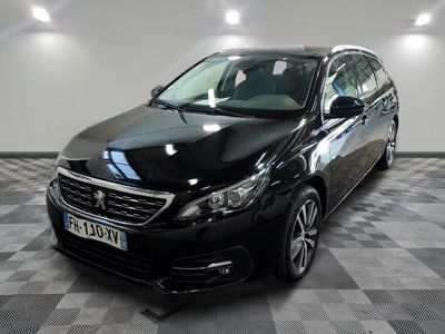 la voiture noire est garée sur un sol en damier dans le garage
