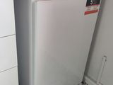 un petit réfrigérateur blanc dans le coin d'une cuisine