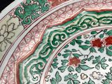 a close up of a plate with flowers and vines on it