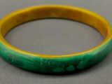 un gros plan d'un bracelet vert et jaune posé sur une table
