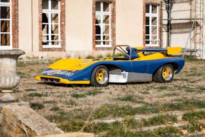 une voiture de course bleue et jaune garée devant un immeuble
