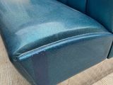 a blue couch that is sitting on a carpeted floor