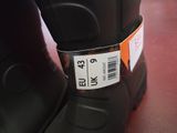 a label on a pair of black boots on a red floor