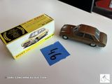 une petite voiture miniature posée à côté d'une boîte sur une table