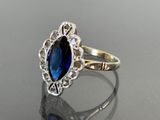 a close up of a ring with a blue stone in it