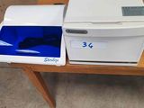 a white and blue printer sitting on a wooden table