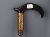 an old cane with a stick handle on a gray surface