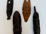 trois masques en bois accrochés les uns à côté des autres sur un mur