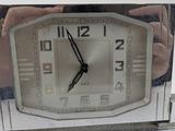 a silver clock with a picture of a woman on it