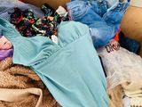 a cardboard box full of clothes and clothes on the floor