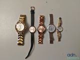 Plusieurs montres différentes sont alignées sur une table